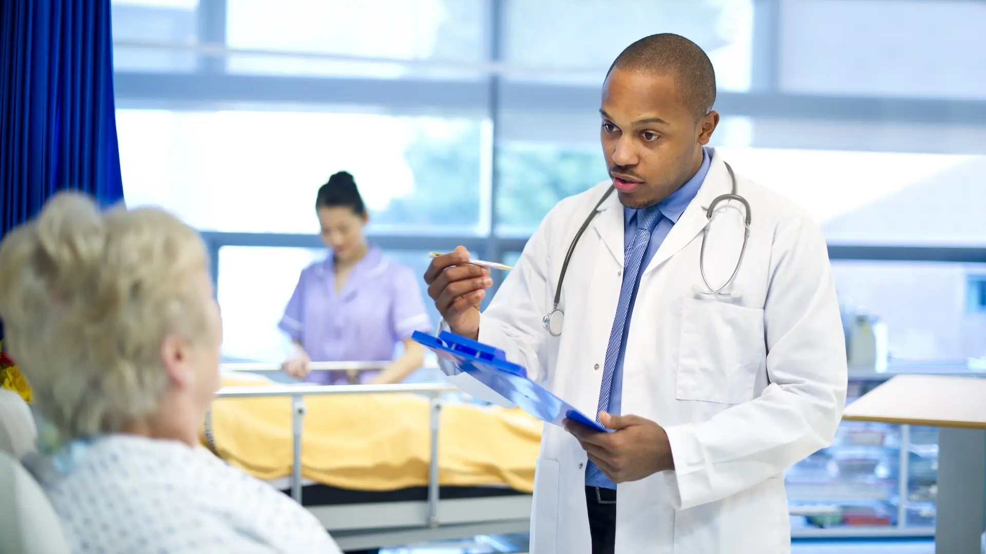 Doctor talking to a patient on a hospital ward