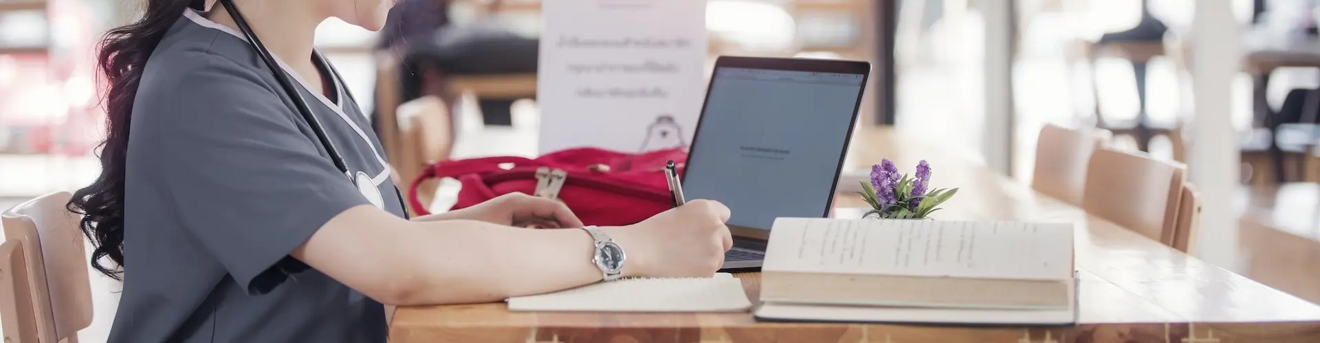 Medical student studying with laptop and textbook