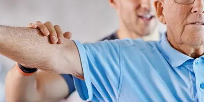 Physiotherapist helping patient exercise